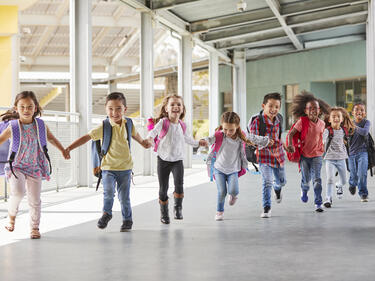 Elementary kids run holding hands