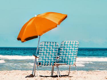 Two Beach chairs on the Beach under an umbrella